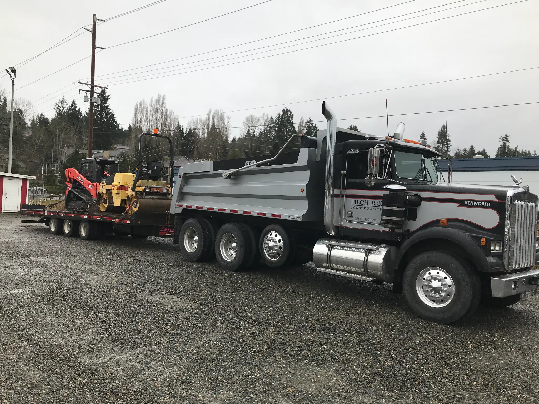 Pilchuck Construction dump truck and heavy equipment staged at commercial construction site
