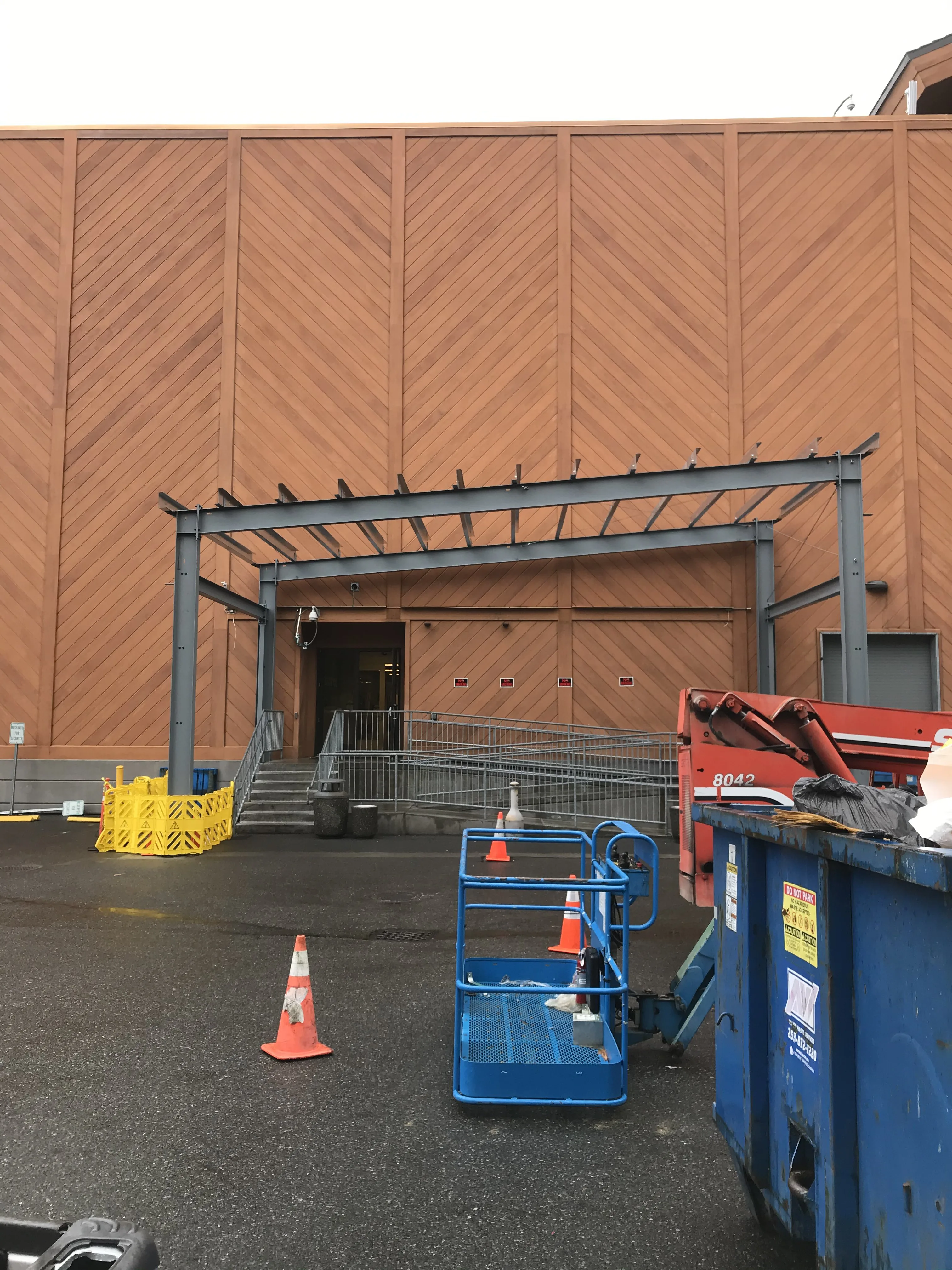 Steel canopy frame under construction at commercial building entrance