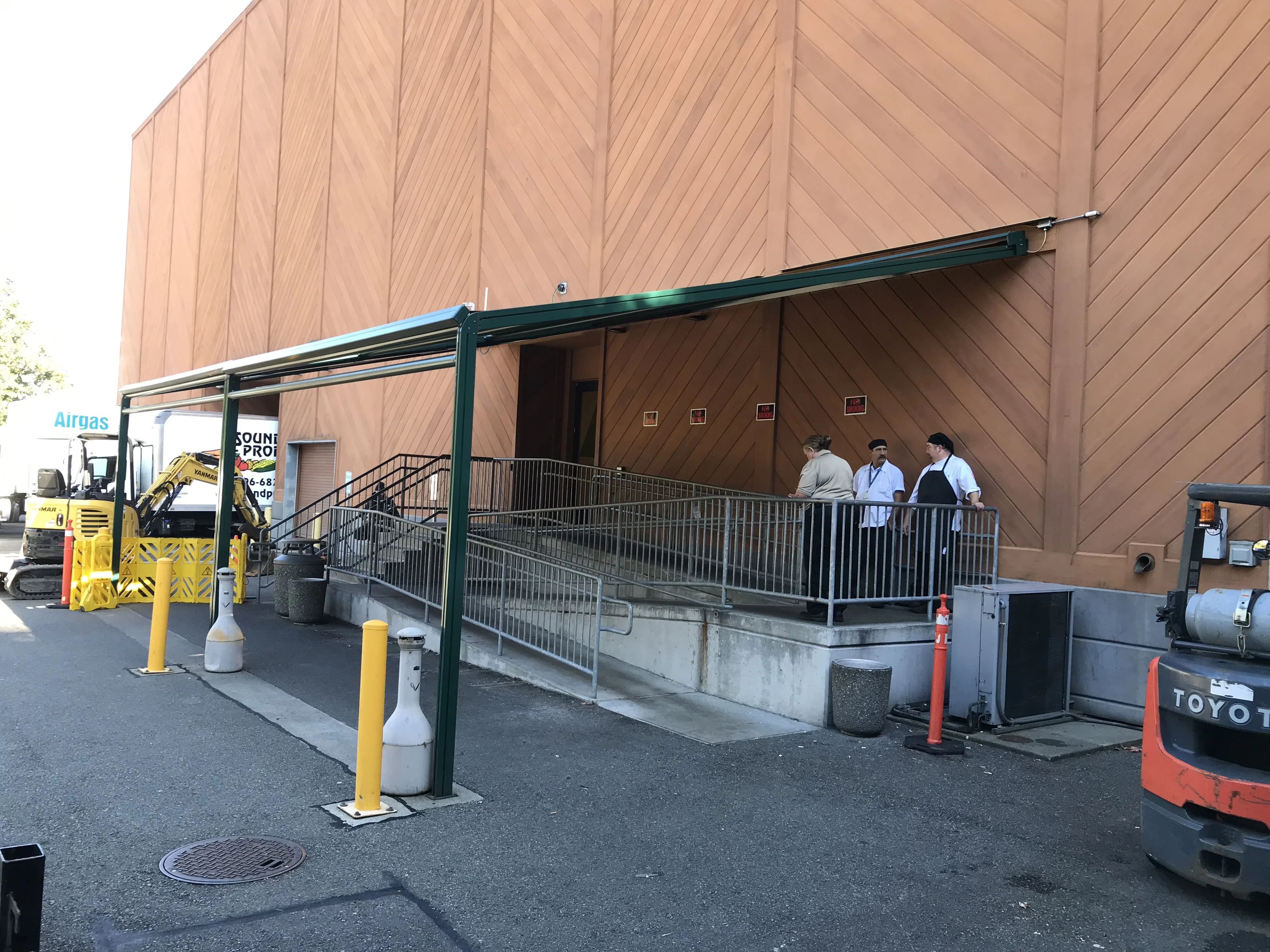 Completed canopy with people on ramp and business operating during construction