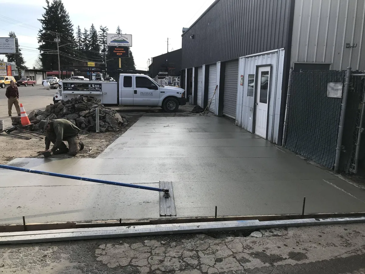 New concrete sidewalk and apron work outside a commercial service building in Western Washington
