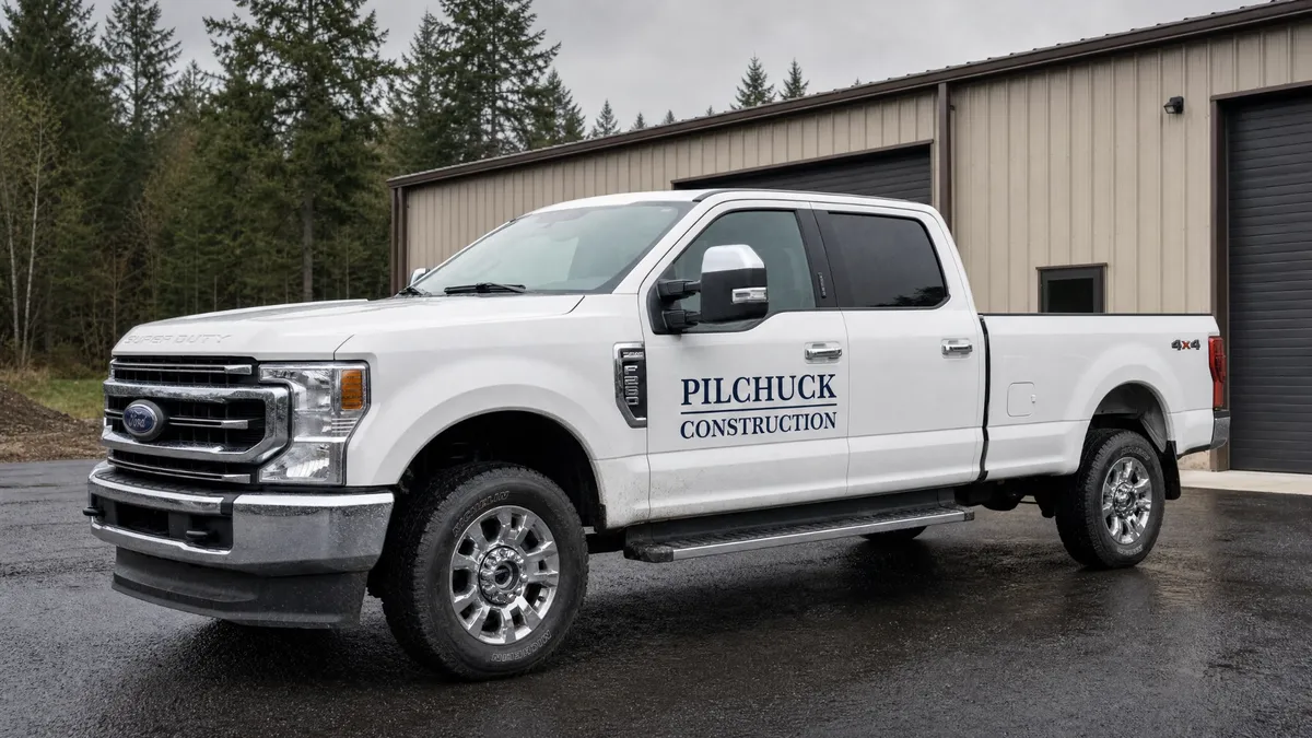 Pilchuck Construction branded Ford Super Duty truck parked in front of a steel building in Western Washington