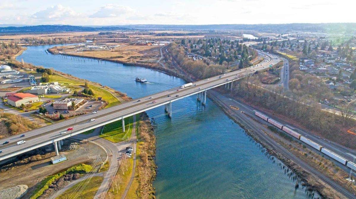 Aerial view of a Western Washington commercial corridor showing site access conditions near a highway and river crossing