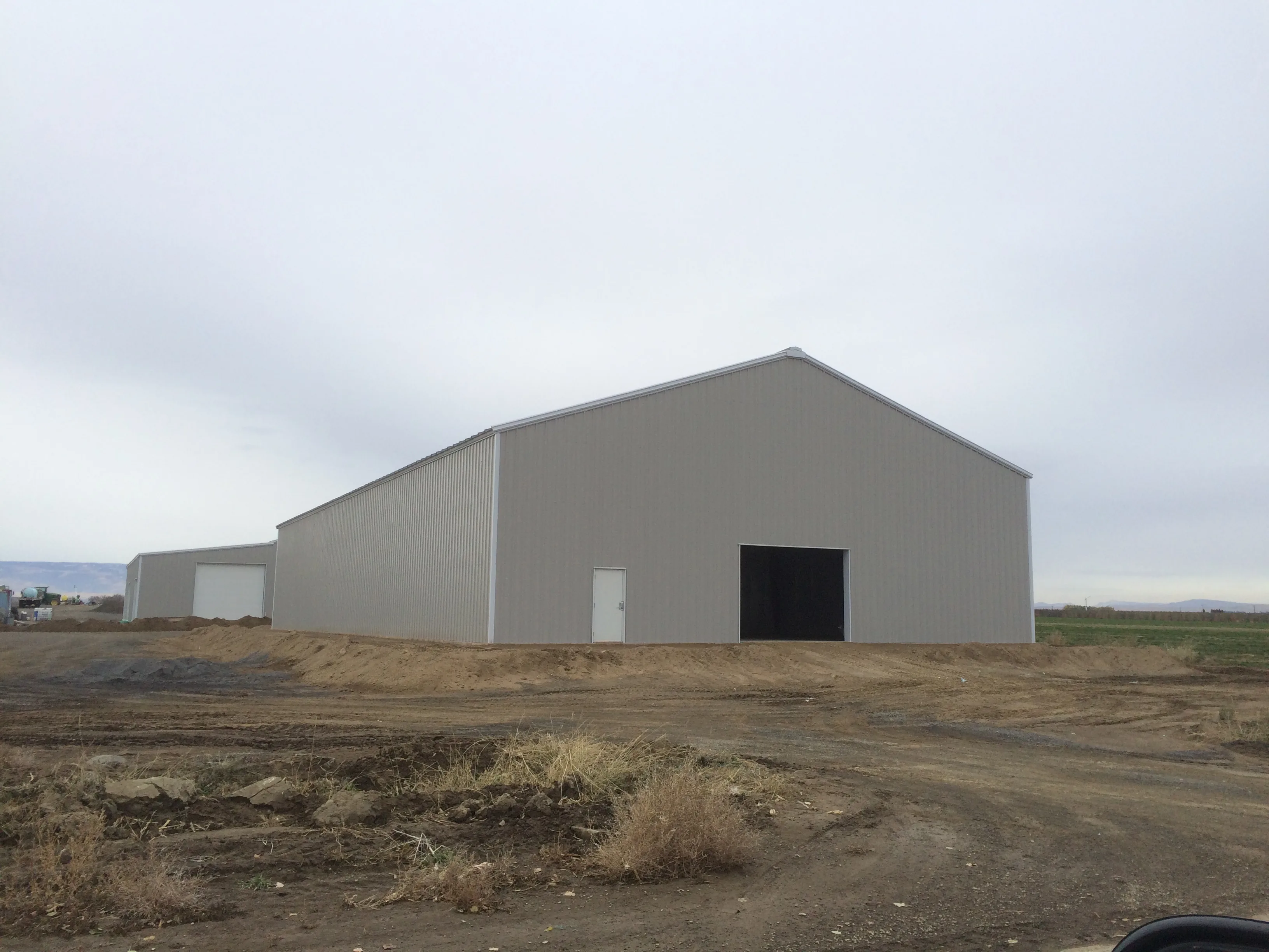 Completed large agricultural steel building with gray metal panels